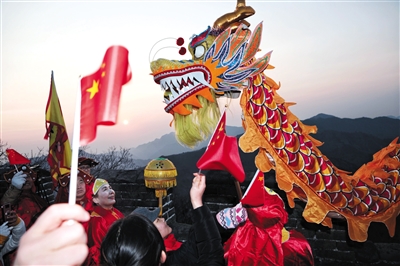 2019年1月1日，迎着日出，长城上表演起了舞龙，游客在庆祝新年的到来。
